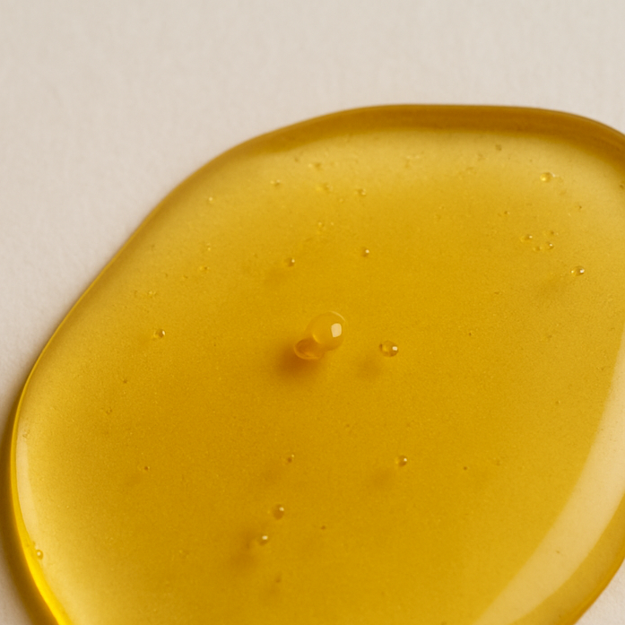 Detailaufnahme der goldenen Textur des Giola Fellöls für Hunde – reichhaltige Pflege für glänzendes Fell.