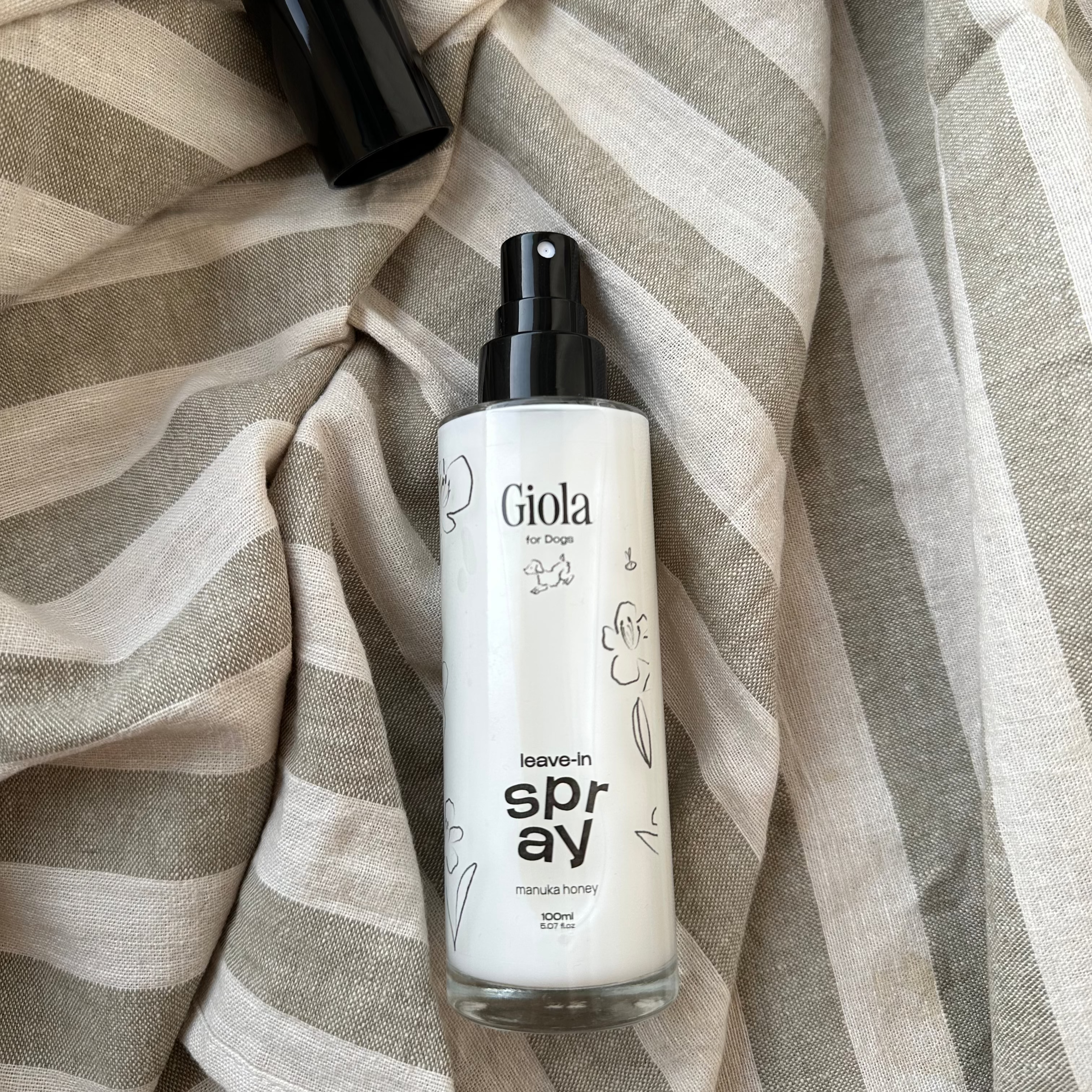 Giola Fellspray für Hunde – Leave-In Spray mit Manuka Honig, Produktfoto auf Stoffunterlage